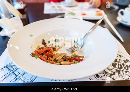 I piatti sporchi. salsa spalmato su una piastra. su scuro dello sfondo in legno Foto Stock