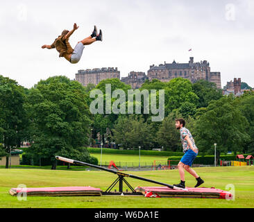 Edimburgo, Scozia, Regno Unito, 1 agosto 2019. Edinburgh Festival Fringe: il finlandese acrobatico cast di Fringe mostrano Super domenica da corsa di cavalli azienda usa un teeterboard di lanciare stessi nell'aria sopra i prati con la skyline di Edimburgo e il Castello di Edimburgo in background. Nella foto: L a R acrobati Rauli Dahlberg e Jarno Polhuijs Foto Stock