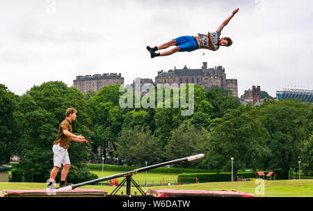 Edimburgo, Scozia, Regno Unito, 1 agosto 2019. Edinburgh Festival Fringe: il finlandese acrobatico cast di Fringe mostrano Super domenica da corsa di cavalli azienda usa un teeterboard di lanciare stessi nell'aria sopra i prati con la skyline di Edimburgo e il Castello di Edimburgo in background. Nella foto: L a R acrobati Rauli Dahlberg e Jarno Polhuijs Foto Stock