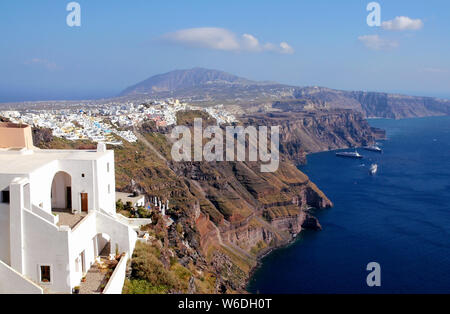 Santorini, Grecia presi da Oia Santorini guardando in direzione di Fira. Vista panoramica delle scogliere della caldera di Santorini e il porto con tre navi da crociera Foto Stock