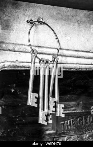 Vecchio ferro battuto chiavi appeso a un caminetto Foto Stock