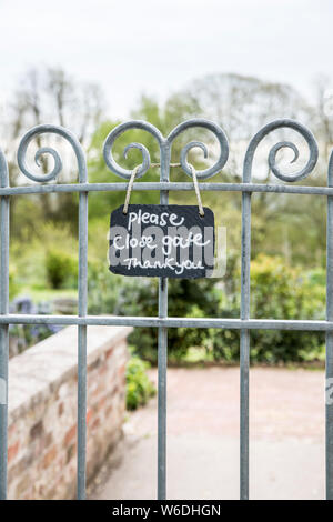 Si prega di chiudere la porta segno sul cancello del giardino Foto Stock