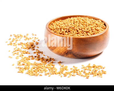 Fenugreek (Trigonella) in una coppa di legno su sfondo bianco Foto Stock