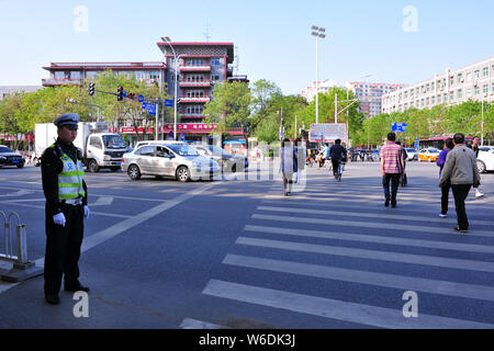 I pedoni a piedi sulle strisce pedonali come la luce rossa si accende in verde nella parte anteriore di uno schermo per la visualizzazione delle immagini dei pedoni cercando di attraversare le strade illegall Foto Stock