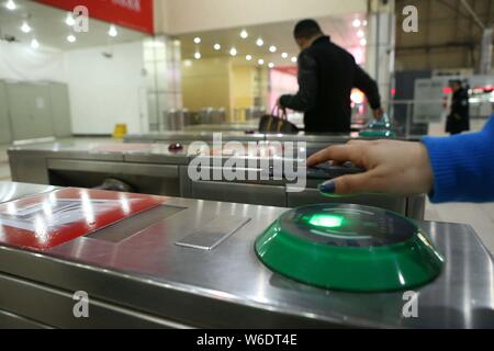 --FILE--un passeggero mette il suo smartphone al di sopra di un tornello per avere il codice QR su un mobile app scansionati a pagare per il biglietto della metropolitana via Alipay o Cina Uni Foto Stock
