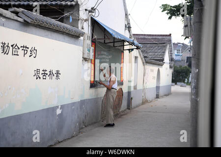 (190801) -- HEXIAN, 1 Agosto, 2019 (Xinhua) -- Ye Lianping scrive news abstracts su una lavagna al di fuori della classe del 'home per sinistra-dietro i bambini' in Buchen villaggio di Hexian County, est cinese della provincia di Anhui, 31 luglio 2019. Ye Lianping, un 92-anno-vecchio insegnante in pensione in Buchen villaggio di Hexian County, impostare la 'casa di sinistra-dietro i bambini" nel 2000 per insegnare loro le lezioni di inglese per libero. Come la maggior parte dei giovani lavorano lontano, gli anziani e i bambini sono lasciati alle spalle nel villaggio. Con nessun bambino stesso, Voi vive con sua moglie in un bungalow costruito 30 anni fa, dove egli offre tho Foto Stock