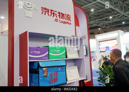 --FILE--un visitatore viene visto allo stand di JD Logistica cinese del rivenditore online JD.com durante una mostra a Shanghai in Cina, 13 aprile 2018. Chi Foto Stock