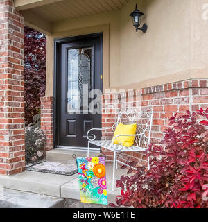 Portico quadrato e il giardino di casa con vetrata di vetro della porta anteriore e del calcestruzzo e un muro di mattoni Foto Stock