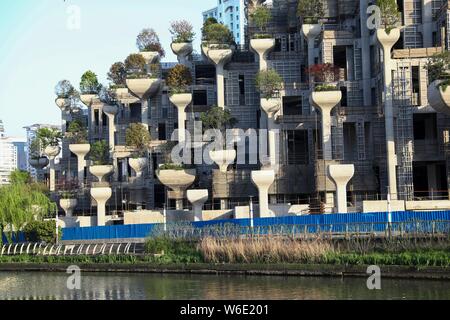 L'edificio straordinario con la forma dei giardini pensili di Babilonia è in costruzione in Cina a Shanghai, 10 aprile 2018. L'edificio straordinario Foto Stock