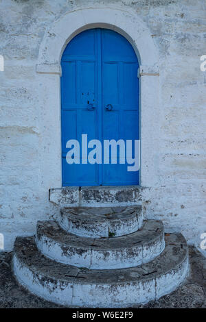 Porte blu e passi in un dipinto di bianco cappella del villaggio sull'isola di Lesbo, Grecia Foto Stock