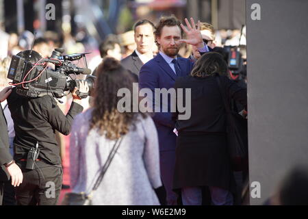 Attore inglese Tom Hiddleston onde come egli arriva sul tappeto rosso di un evento promozionale per il suo nuovo film 'vendicatori: guerra infinita' di Shanghai, mento Foto Stock