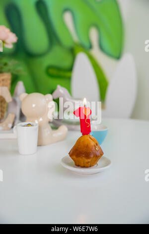 Numero uno candela di compleanno sul cupcake su una tabella wwhite.L'immagine verticale.festa di compleanno con cupcake,Candle.festeggiare il 1° compleanno, saluto Foto Stock