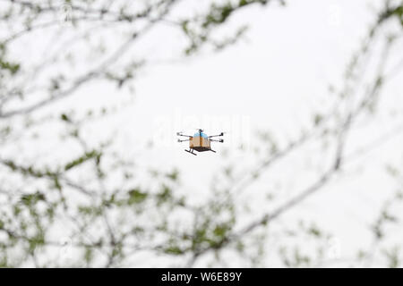 Un drone o UAV (Unmanned Aerial Vehicle) di Alibaba Cainiao della logistica molla porta le foglie di tè vola sopra le montagne in una piantagione di tè in Han Foto Stock
