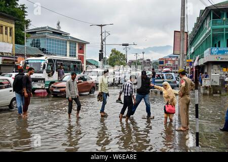 Srinagar, India. 01 Ago, 2019. Residenti wade dopo le pesanti piogge di Srinagar.piogge causate acqua-logging in molte aree di Srinagar esponendo il povero sistema di drenaggio della città. Il servizio meteo ha predetto pioggia pesante per i prossimi giorni in tutta la regione. Credito: SOPA Immagini limitata/Alamy Live News Foto Stock