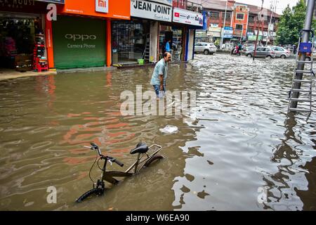 Srinagar, India. 01 Ago, 2019. Un uomo wades dopo le pesanti piogge di Srinagar.piogge causate acqua-logging in molte aree di Srinagar esponendo il povero sistema di drenaggio della città. Il servizio meteo ha predetto pioggia pesante per i prossimi giorni in tutta la regione. Credito: SOPA Immagini limitata/Alamy Live News Foto Stock