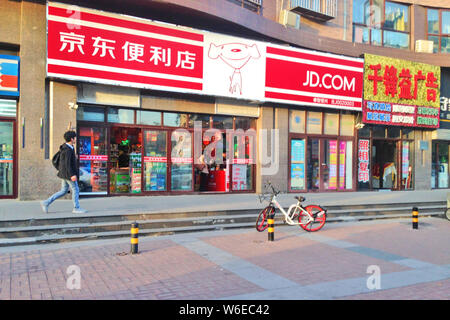 --FILE--A passeggiate a piedi passato un JD Convenience Store a Pechino in Cina, 7 novembre 2017. Il paese il secondo più grande sito di e-commerce JD presenta offic Foto Stock