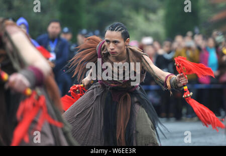 La gente di Yi gruppo etnico vestite nei tradizionali costumi Yi pregare per le benedizioni e la buona fortuna duirng un rito di sacrificio di rododendri in Qianxi co Foto Stock