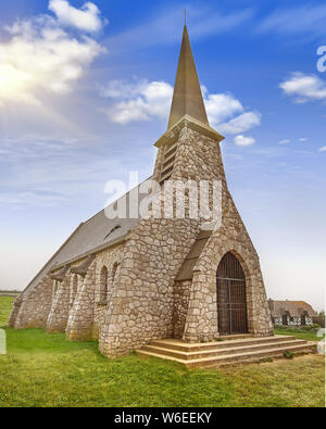 Chapelle Notre Dame de la Garde in Etretat, Haute Normandie, Francia - la vecchia pietra villaggio medievale chiesa normanna in Europa in una giornata di sole con verde Foto Stock