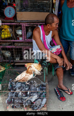 Un uomo la vendita di volatili vivi al mercato del carbonio, Cebu City Cebu, Filippine Foto Stock