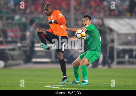 Calcio ecuadoriana player Jaime Ayovi di Pechino Renhe, sinistra, sfide Zhang Yu di Pechino Guoan Sinobo nel loro quarto round corrispondere durante il 2018 Foto Stock