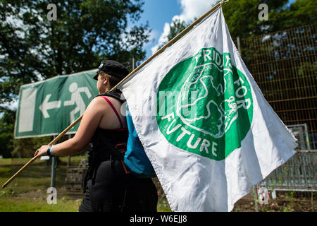 Dortmund, Germania. 01 Ago, 2019. Un giovane partecipante della 'Summer Congress" del venerdì per il movimento futuro passa in un uscita di emergenza segno nel Revierpark con lei il venerdì per la futura bandiera. Giovedì, 01.08.2019, workshop e dibattiti con scienziati e politici inizierà a. Gli organizzatori vogliono conseguire una migliore messa in rete, promuovere lo scambio di esperienze e di discutere il futuro corso insieme. Credito: Guido Kirchner/dpa/Alamy Live News Foto Stock