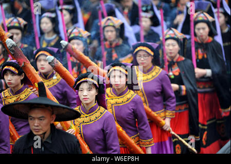 La gente di Yi gruppo etnico vestite nei tradizionali costumi Yi pregare per le benedizioni e la buona fortuna duirng un rito di sacrificio di rododendri in Qianxi co Foto Stock