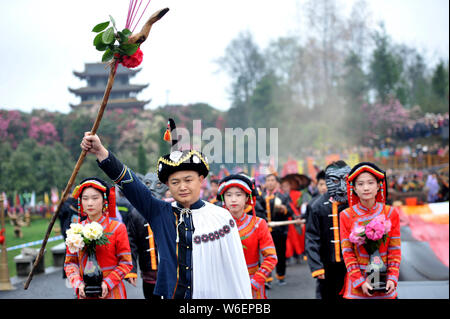 La gente di Yi gruppo etnico vestite nei tradizionali costumi Yi pregare per le benedizioni e la buona fortuna duirng un rito di sacrificio di rododendri in Qianxi co Foto Stock