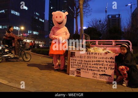 Padre cinese Zhou, chi è vestito come Peppa Pig per raccogliere denaro per il trattamento delle sue tre-anno-vecchio figlia con diabete mellito di tipo 1, Foto Stock