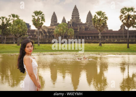 Emancipated asiatica donna solista traveler ad esplorare il tempio di Angkor Wat, Siem Reap, Cambogia in abito bianco Foto Stock