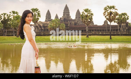 Emancipated asiatica donna solista traveler ad esplorare il tempio di Angkor Wat, Siem Reap, Cambogia in abito bianco Foto Stock