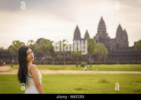 Emancipated asiatica donna solista traveler ad esplorare il tempio di Angkor Wat, Siem Reap, Cambogia in abito bianco Foto Stock