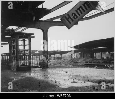 Avviso per gli spostamenti del nemico, privato di prima classe Armand Rindone, Philadelphia, Pennsylvania, si accovaccia con una carabina presso la stazione ferroviaria in appena catturato Città di Hamm, Germania.; Note Generali: Utilizzo di guerra e di conflitto numero 1093 quando si ordina una riproduzione o la richiesta di informazioni su questa immagine. Foto Stock