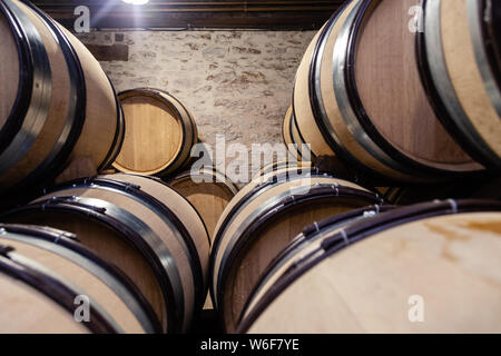 Vino di legno botti di rovere accatastate in file diritte in ordine, antica cantina della cantina, volte. Concetto brewery sfondo, degustazione professionale, winelov Foto Stock