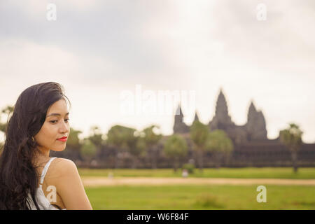 Emancipated asiatica donna solista traveler ad esplorare il tempio di Angkor Wat, Siem Reap, Cambogia in abito bianco Foto Stock