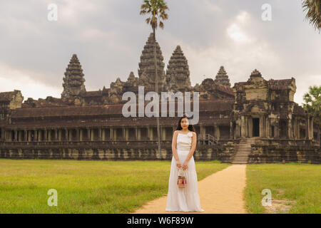 Emancipated asiatica donna solista traveler ad esplorare il tempio di Angkor Wat, Siem Reap, Cambogia in abito bianco Foto Stock