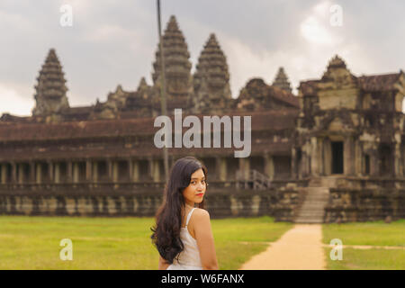 Emancipated asiatica donna solista traveler ad esplorare il tempio di Angkor Wat, Siem Reap, Cambogia in abito bianco Foto Stock