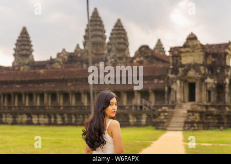 Emancipated asiatica donna solista traveler ad esplorare il tempio di Angkor Wat, Siem Reap, Cambogia in abito bianco Foto Stock