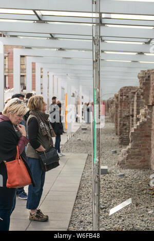 Berlino, Germania - 26 settembre 2018: penetrante prospettiva verso l'interno di turisti in piedi vicino al muro di Berlino alla frontiera di una mostra temporanea di Foto Stock