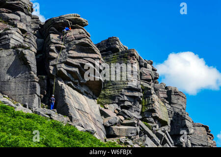 Arrampicatori sul bordo Stanage, Gritstone, Peak District National Park, England, Regno Unito Foto Stock