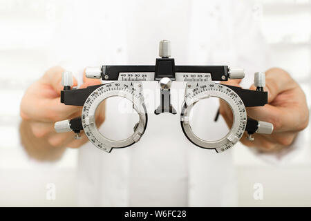 Medico tenendo all'ottico optometrista telaio di prova Foto Stock