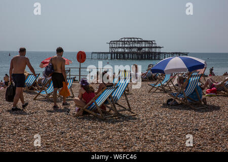 Vacanzieri godere il caldo sul lungomare di Brighton, cittadina balneare nella contea di East Sussex, England, Regno Unito Foto Stock