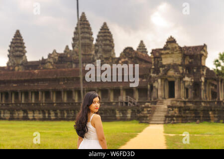 Emancipated asiatica donna solista traveler ad esplorare il tempio di Angkor Wat, Siem Reap, Cambogia in abito bianco Foto Stock