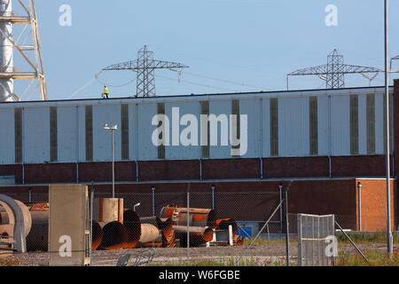 Il tetto del vasto Aberthaw Coal Fired power station sul lato gallese del canale di Bristol con un lavoratore di eseguire interventi di manutenzione sul tetto Foto Stock