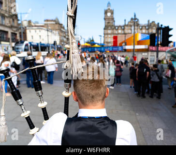 Edimburgo, Scozia, Regno Unito. 1 agosto 2019. Giovane maschio piper riproduzione di cornamuse per turisti su Princes Street di Edimburgo, Regno Unito. Vi è un grande afflusso di turisti in città in vista dell'inizio dell'International e Fringe Festival di venerdì 2 agosto, 2019. Foto Stock