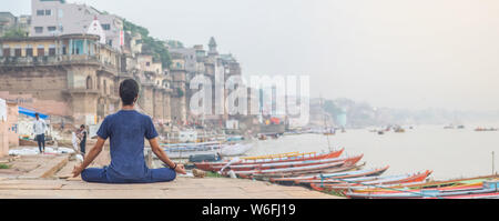 Insegnante di Yoga Ayush meditando sul fiume Gange a Varanasi a sunrise. Foto Stock