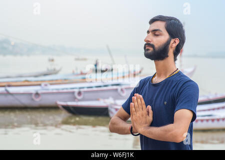 Insegnante di Yoga Ayush meditando sul fiume Gange a Varanasi a sunrise. Foto Stock