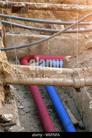 Blu e rosso tubo di acqua nel terreno Foto Stock