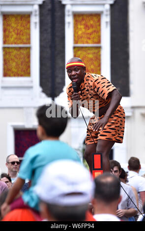 Londra, Inghilterra, Regno Unito. Street performer di Covent Garden (acrobata e giocoliere) - Giovane ragazzo guardando su di suo padre a spallamenti Foto Stock