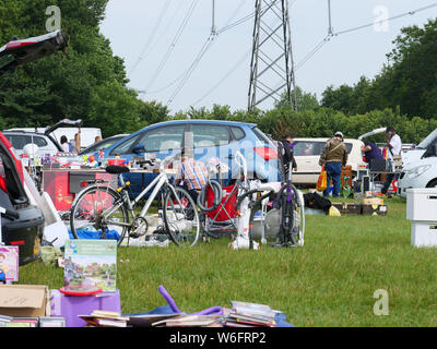 Persone che vendono il loro buon indesiderati per un buon prezzo su un bagagliaio della vettura in vendita in un campo alla periferia di Londra in una domenica di giugno. Foto Stock