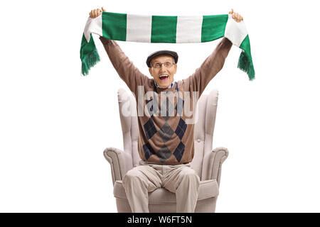 Emozionato senior uomo in una poltrona tifo con una sciarpa isolati su sfondo bianco Foto Stock